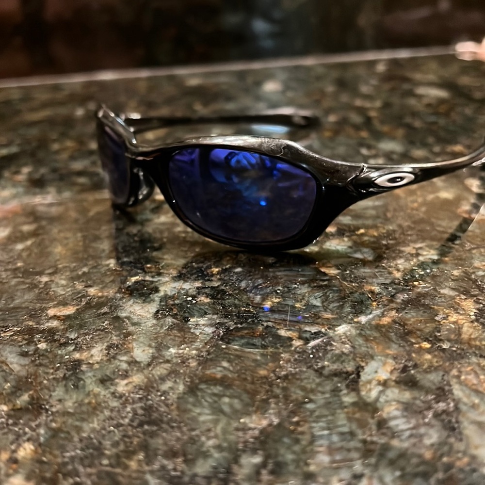 Baby Oakley sunglasses. Black frame with purple blue reflective lense